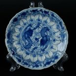 A porcelain plate with two dragons competing for the flaming pearl, embossed with a lotus leaf rim.