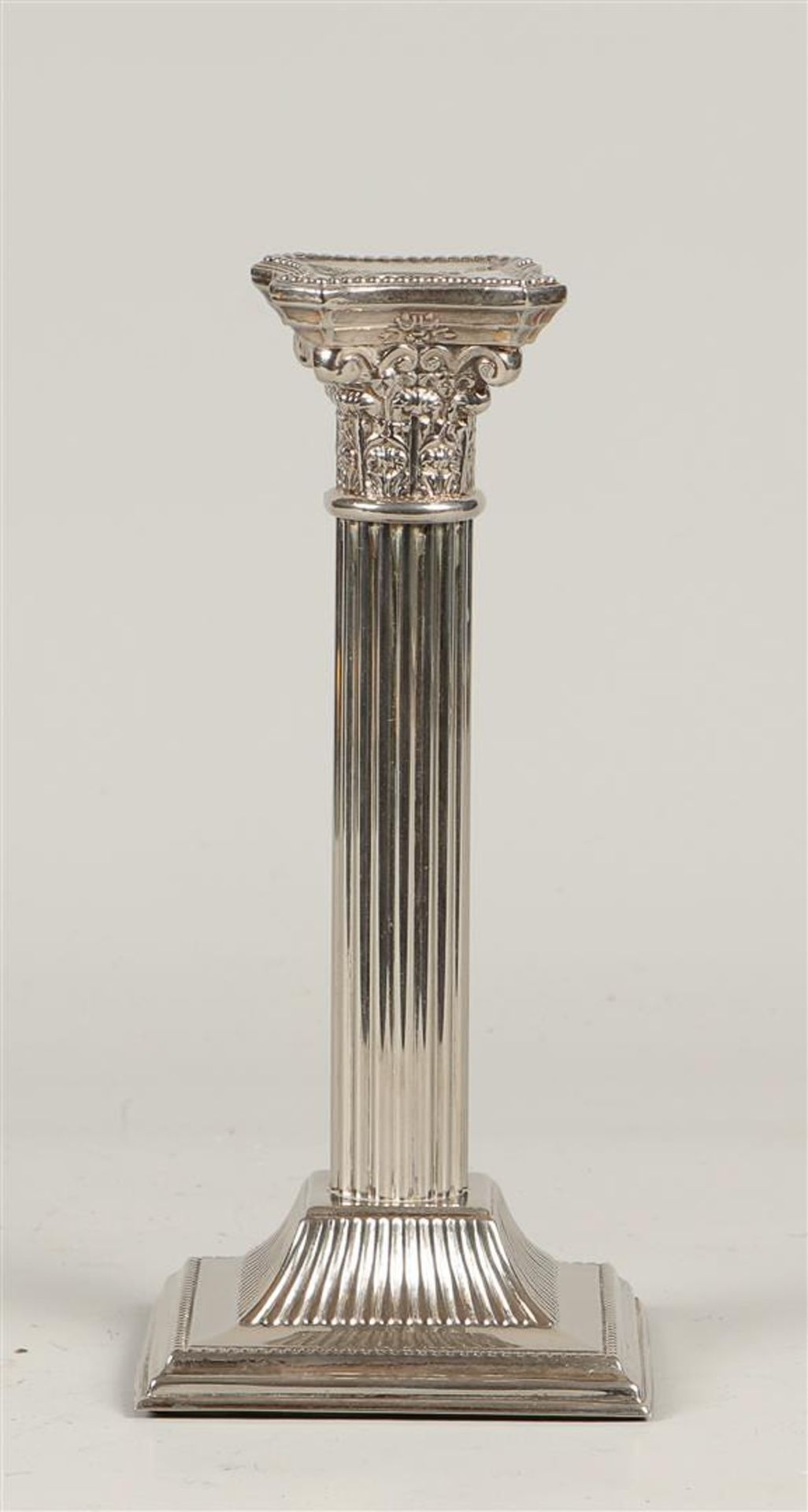 A silver-plated candlestick in the shape of a Corinthian column, marked "Made in England" (on the fo