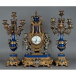 A Garniture de Chéminée consisting of a mantel clock with enamel dial. The bell statues consisting o