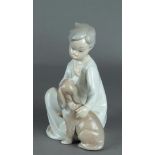 A porcelain figure in the shape of a child with dog, marked Lladro. Spain, 20th century.