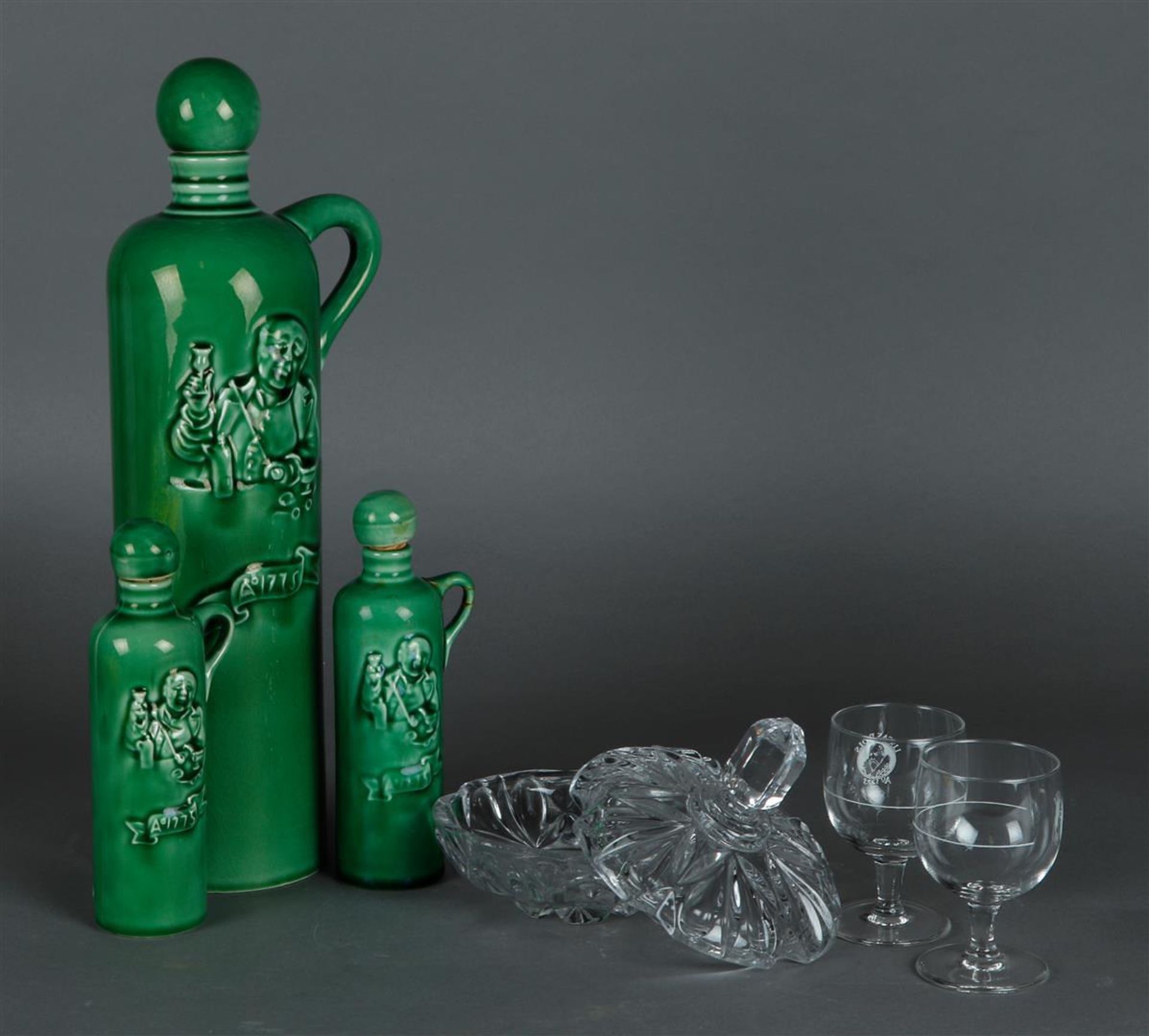 A Lucas Bols liqueur set consisting of (3) earthenware bottles and (2) glasses. In addition, a press