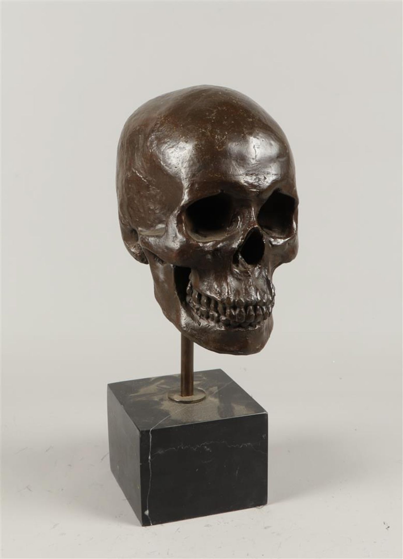 A brown patinated bronze sculpture in the shape of a skull, on a marble base. - Bild 2 aus 2