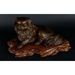 A bronze Pekingese dog, marked on the bottom, on a wooden base. Japan, Meji period.