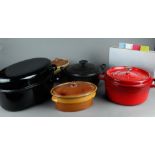 An Acotte Staub cast iron red enamel casserole. In addition, a Joseph Joseph cutting board set. In a