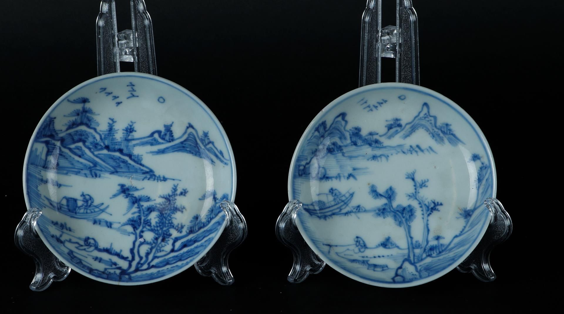 Two porcelain plates with a river landscape with a fisherman in a boat. China, Yongzheng.