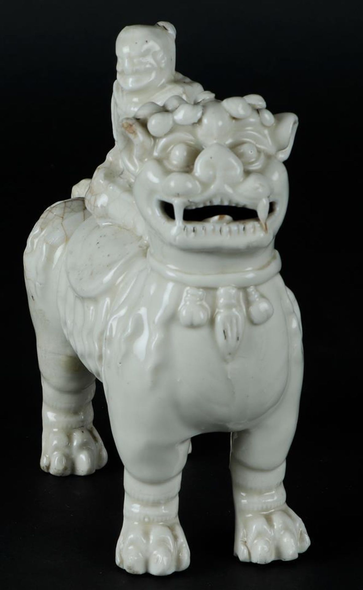 A porcelain blanc de chine foo dog with a figure on it. China, Kangxi. - Image 2 of 6