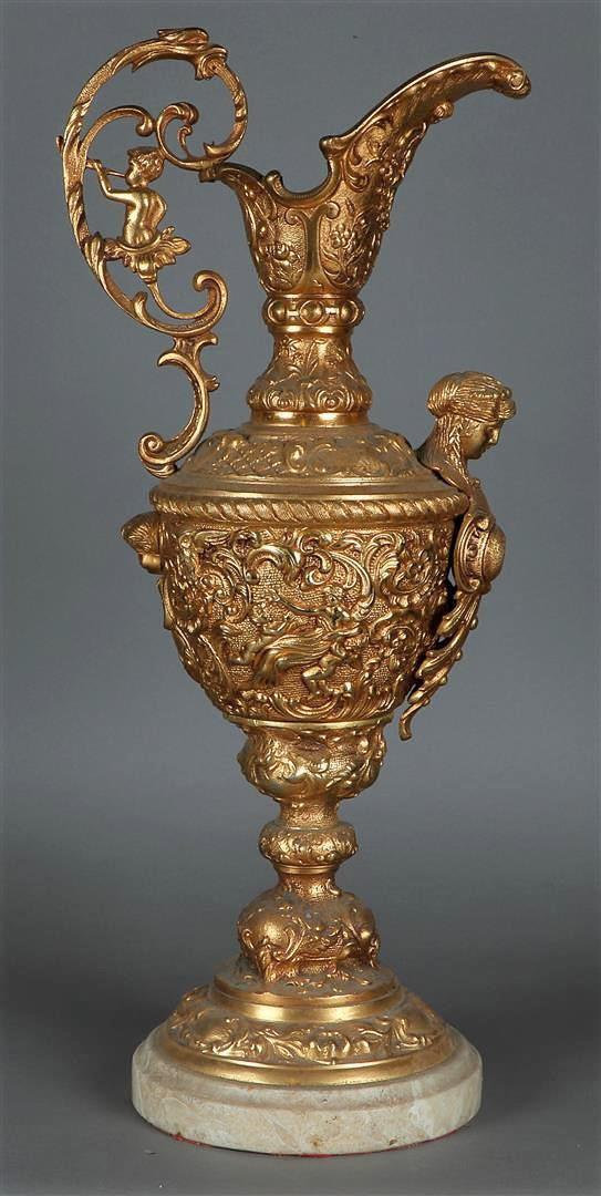 A large richly decorated bronze wine jug on a marble base. France, 19th century.