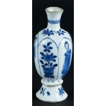A porcelain baluster-shaped vase with knob in the foot, decoration on the belly. China, Kangxi.