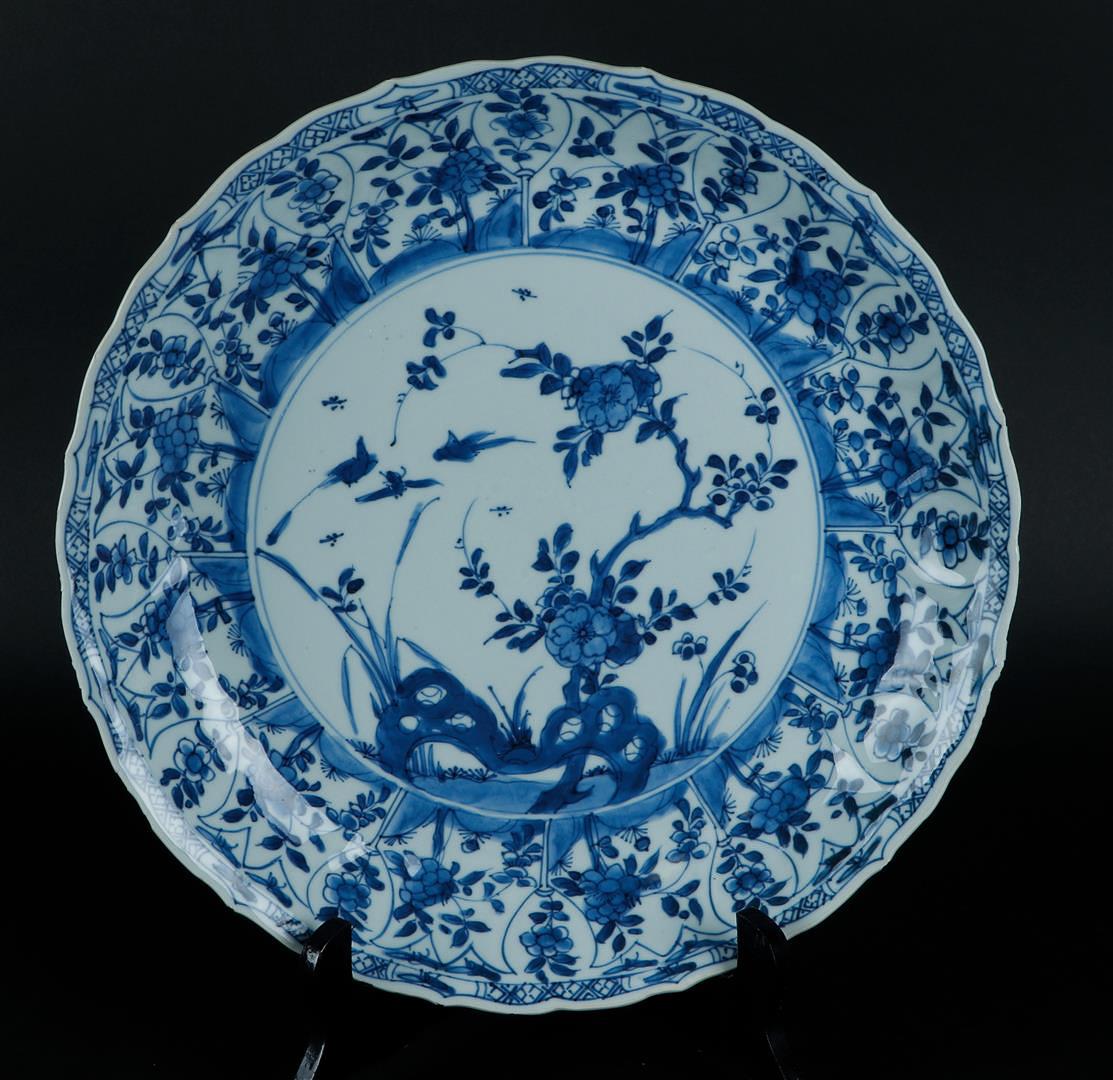 A porcelain dish with a tulip-shaped outer rim with floral decor, the center with flower-on-rock dec