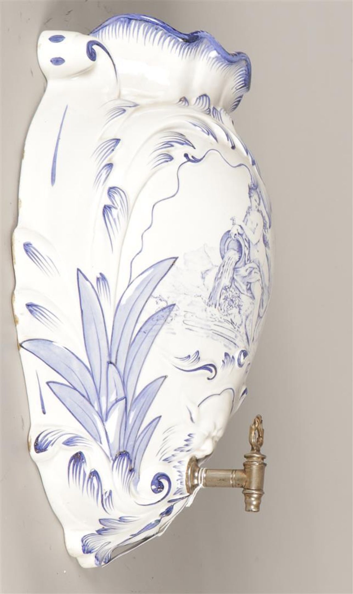 An earthenware water tank with decoration in blue and white and equipped with a tap. Approx. 1900.