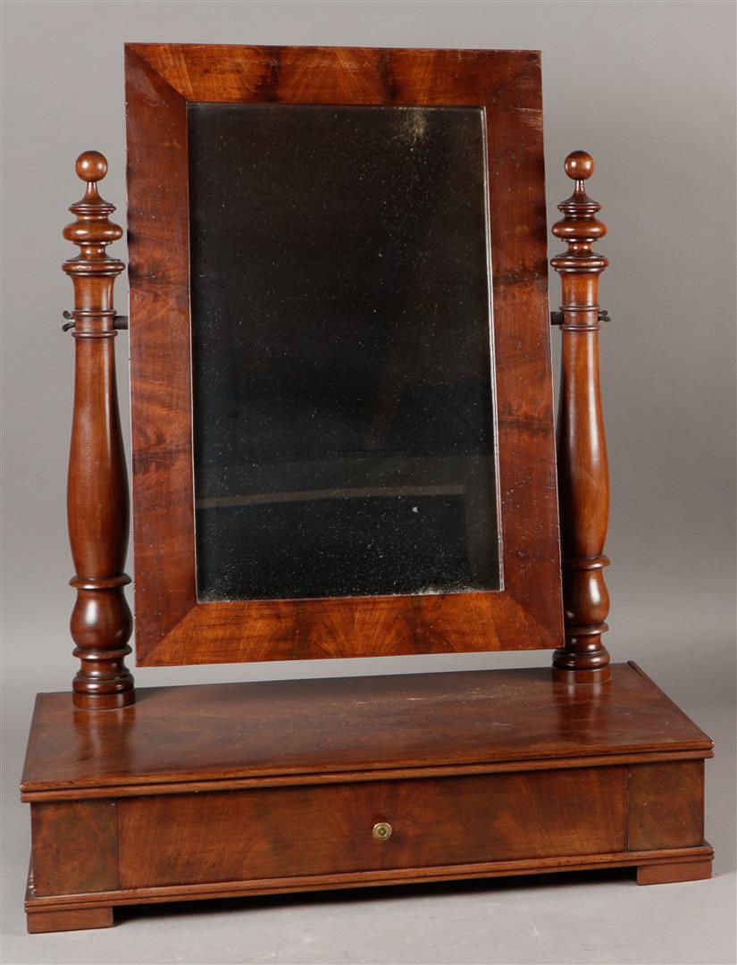A mahogany tilting mirror with a drawer underneath. 19th century.