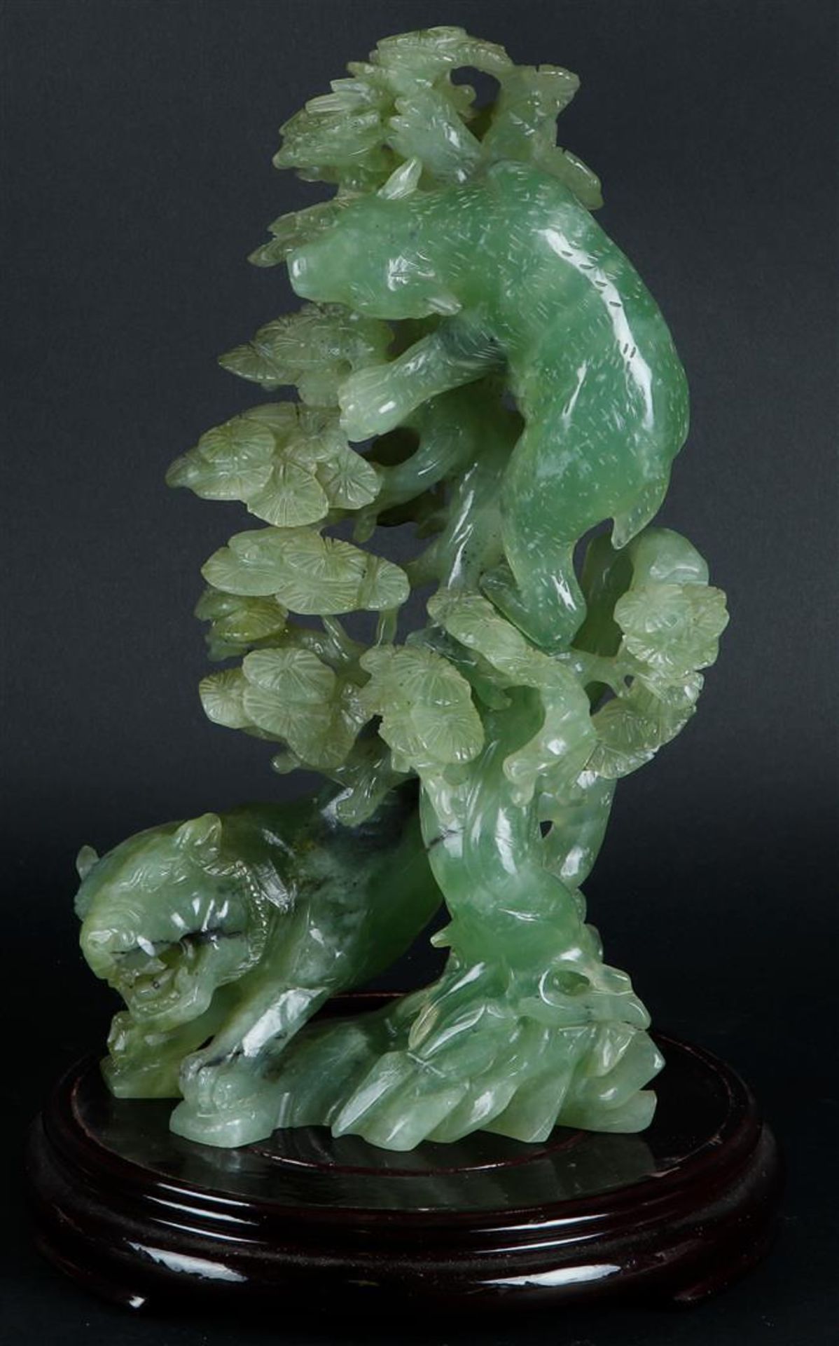 A large Jade statue with decoration of a tiger and a bear near a tree. China, 20th century.