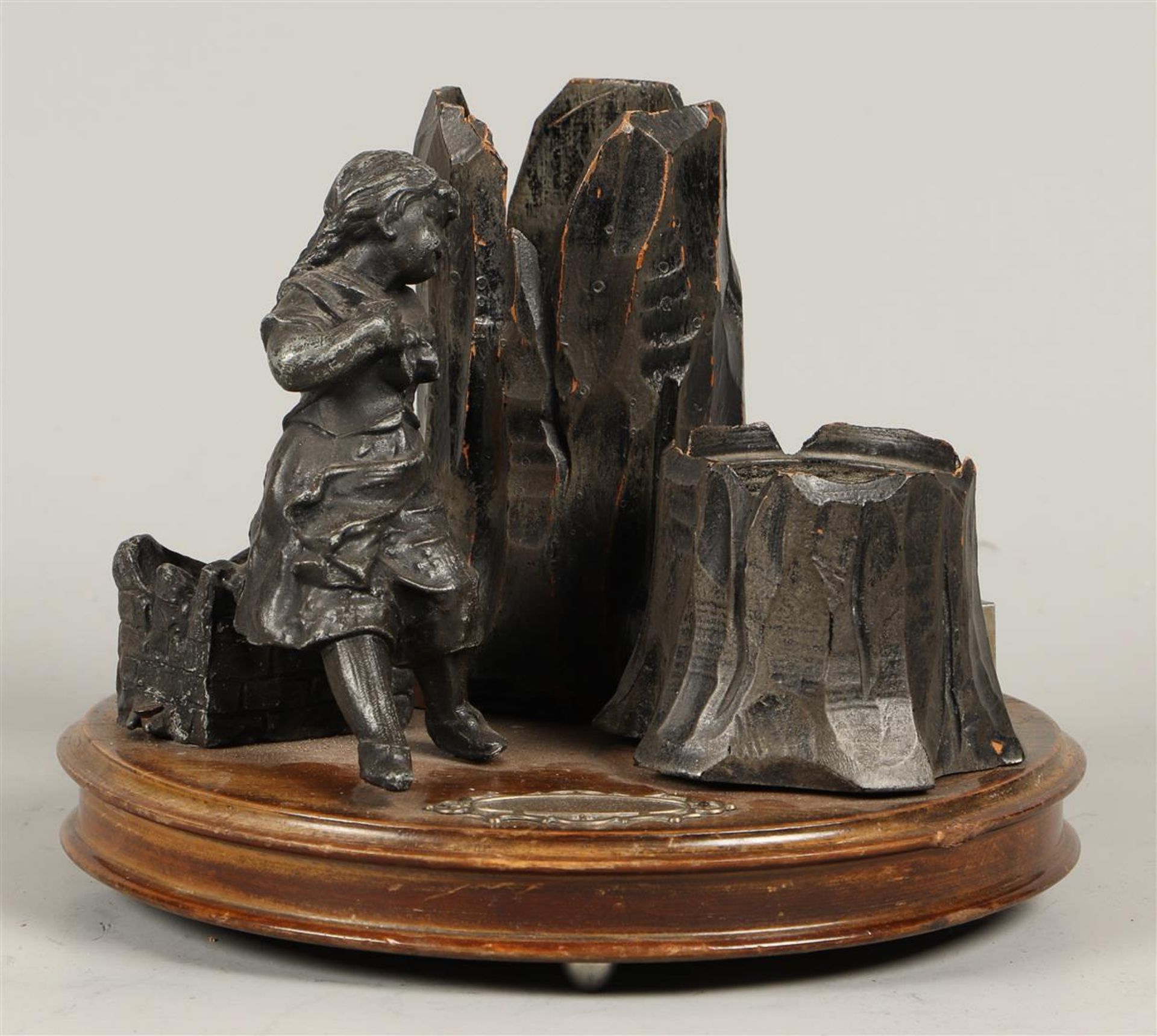 A part wooden smoking desk set depicting a little girl by a tree trunk,  ca. 1900.