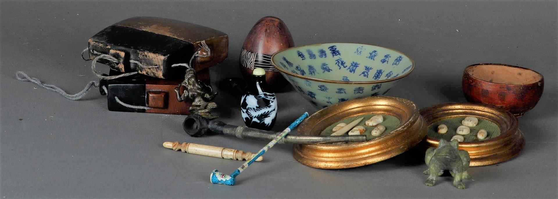 A lot of various Asians. Including opium pipes, bone faces in a frame, a bowl and a frog figure.