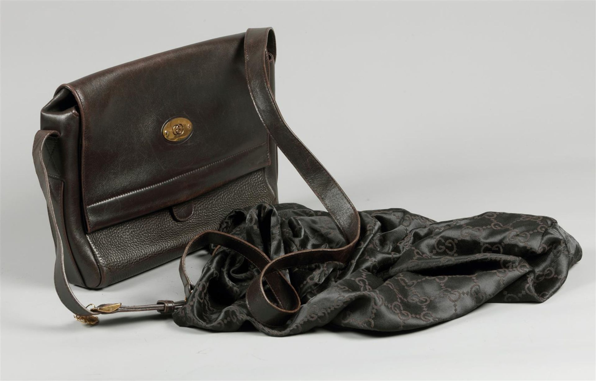 A brown leather Gucci cross body handbag. with accompanying fabric protective bag.