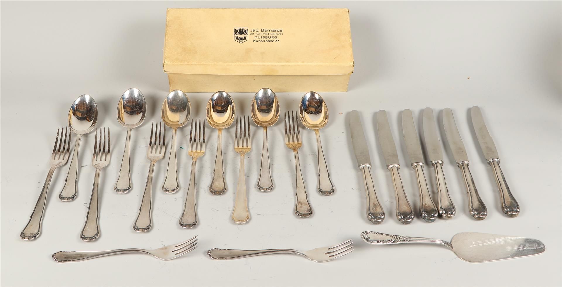 A six-piece silver plated cutlery set consisting of knives, forks, spoons, serving forks and cake se