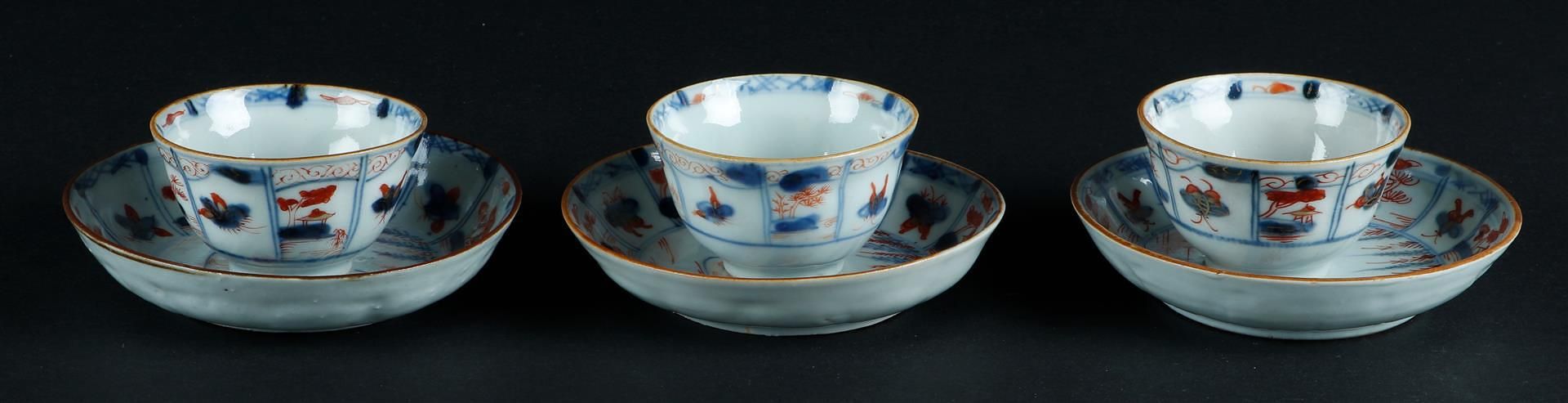 Three porcelain Imari cups and saucers with butterfly decor and floral decor, center with fisherman  - Image 2 of 4