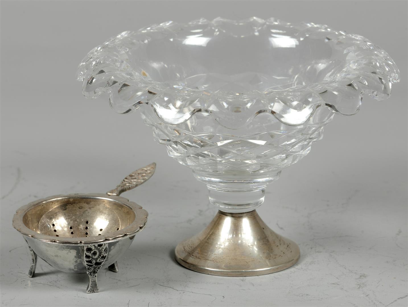 A lot consisting of a silver tea strainer and a cut glass chocolate bowl on a silver base.