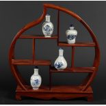 A lot of porcelain snuff bottles with various scenes, on a peach-shaped fruit wooden rack. China, 20