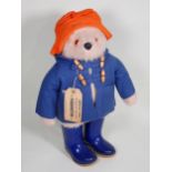 A Paddington Bear Teddy Bear with orange hat, blue coat and wellies