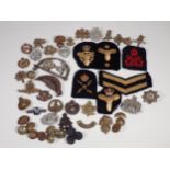 A quantity of military Cap and Shoulder Badges and Buttons including The Border Regiment, East