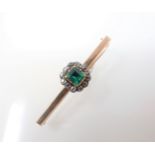 An Emerald and Diamond Brooch set foil backed cushion-cut emerald within a frame of close-set old-