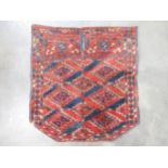 A Turcoman Saddle Rug with stepped and triangular motifs on a red ground, 23 and 22cm