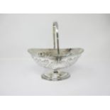 A George III silver oval Basket with later floral embossing, swing handle on pedestal base, London