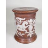 A pottery Garden Seat with brown glaze and decoration of relief moulded mythical figures in white