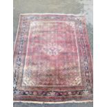 A bordered Hamadan type Rug with central stepped medallion surrounded by stylised flowers on a red