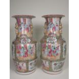 A pair of Cantonese baluster Vases with moulded gilt handles, panels of interior scenes of figures