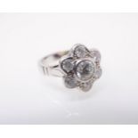 A Diamond Daisy Cluster Ring rubover-set brilliant-cut stone, 0.74cts, within frame of six smaller