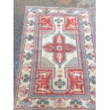 A bordered Kazak type Rug with central star medallion with latch hooks on a camel, red and blue