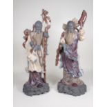 A large pair of Lladro Chinese Figures holding staffs and carrying fruit, in coloured glazes and