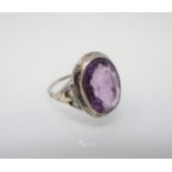 An Amethyst Ring millegrain-set oval-cut stone in engraved white gold mount stamped 18K, ring size M