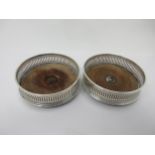 A pair of modern silver pierced circular Coasters with turned wooden bases, London 1983