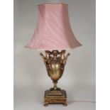 A bronze two handled Table Lamp with figures holding bowl, the handles with leafage, rope twist