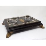 A Victorian ebonised and enamel Inkstand with two inset glass inkwells, the brass covers stamped '