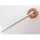 A Coral and Diamond Horseshoe Stick Pin set graduated coral beads with rose-cut diamonds between