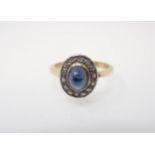 A 1960's Sapphire and Diamond Cluster Ring rubover-set oval cabochon sapphire within a frame of