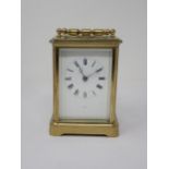 A brass cased Carriage Clock, the enamel dish marked with Roman numerals, name indistinct, 5¼in H