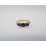 A Sapphire and Diamond Ring pavé-set three cushion cut sapphires interspersed with pairs of old-