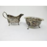 An Edward VII Irish silver Jug and Sugar Bowl embossed birds, dolphins and animals on lion mask