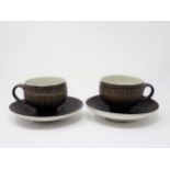 Two Lucie Rie Cups and Saucer in a brown glaze with cream trellis designs, loop handles to the