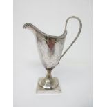 A George III silver helmet shape Cream Jug engraved floral swags, initials in cartouche, beaded