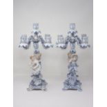 A pair of Dresden blue and white Table Candelabra with floral encrusted arms and leafage sconces