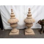 A pair of reconstituted stone Garden Urns with egg and dart band, with pedestal base and square plin