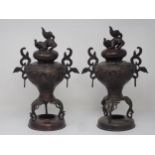 A pair of Chinese bronzed Incense Burners with Dogs of Fo surmounts and with design of flowers in re