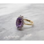 An Amethyst and Diamond Cluster Ring claw-set oval-cut amethyst, 3cts, within a frame of brilliant-c