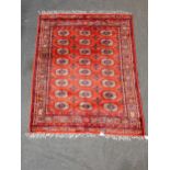 A Tekke Turcoman style Rug with three rows of eight joined guls on a red ground, 5ft 6in x 4ft 4in